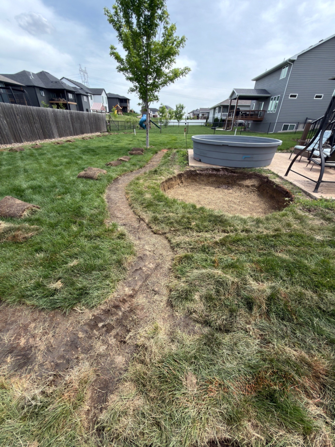During — freshly excavated seat wall area with the new bed shape cut in behind the stock tank patio