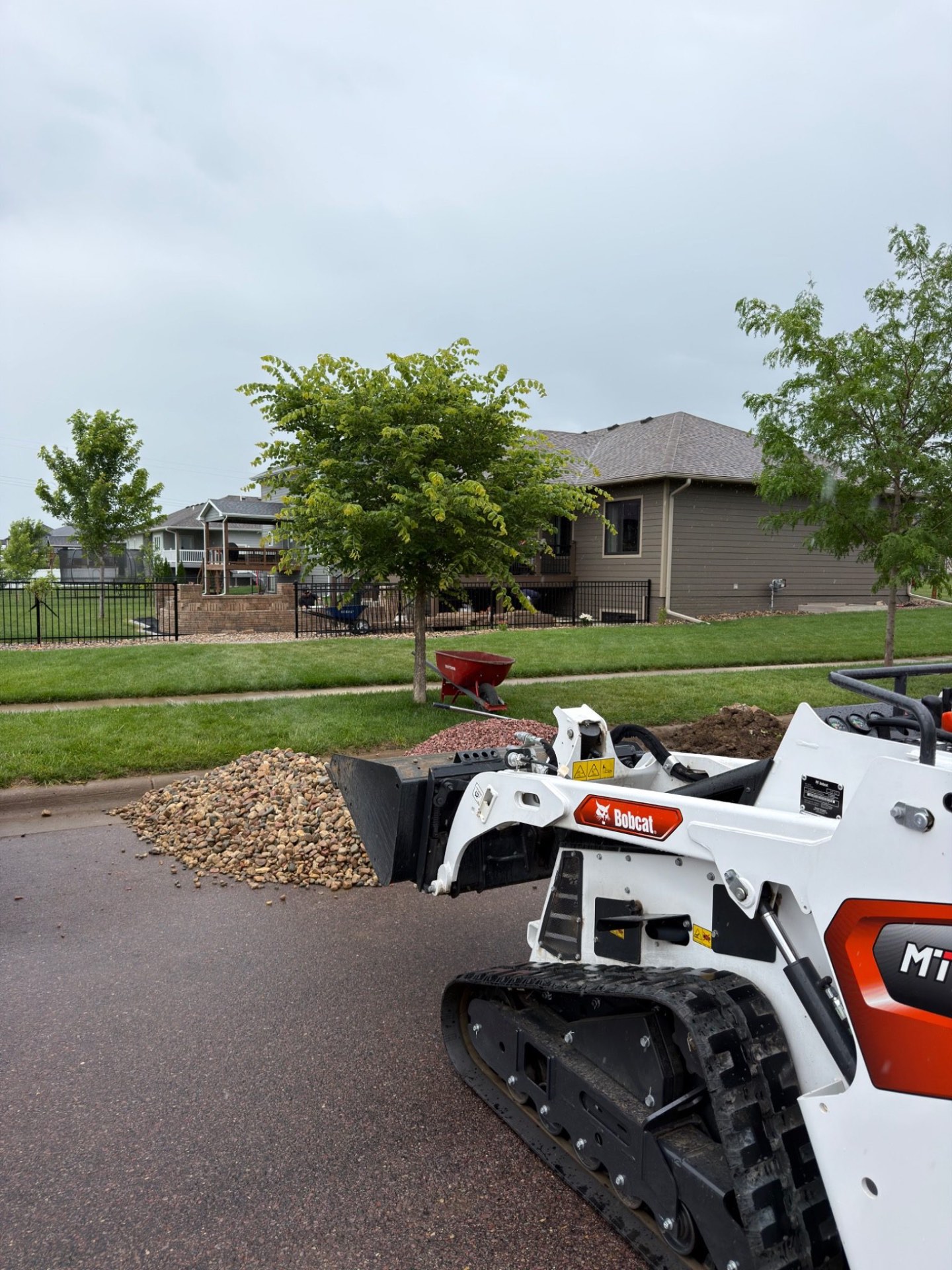 During — mini skid steer and river rock on site as materials are brought in for the surrounding landscape finish work