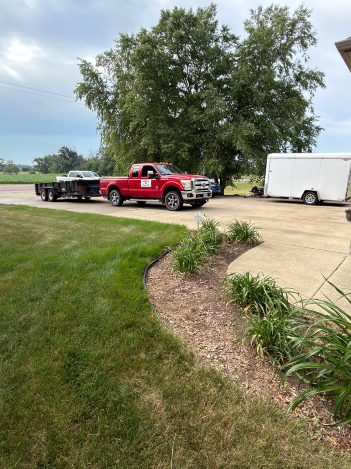Before — Kerwin Property Maintenance trucks and dump trailer on site before the rock install begins