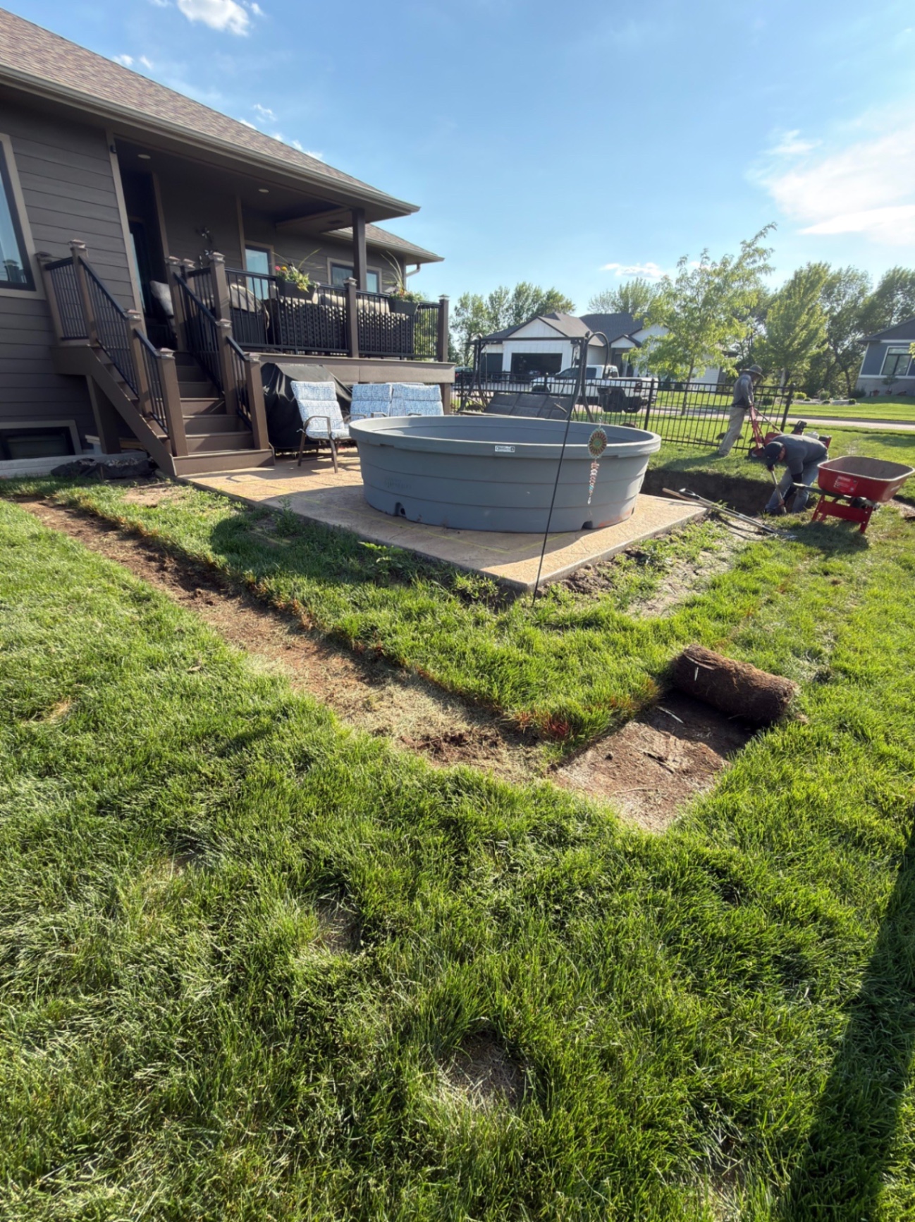 During — crew extending the landscape bed around the stock tank pad and prepping the sod cut