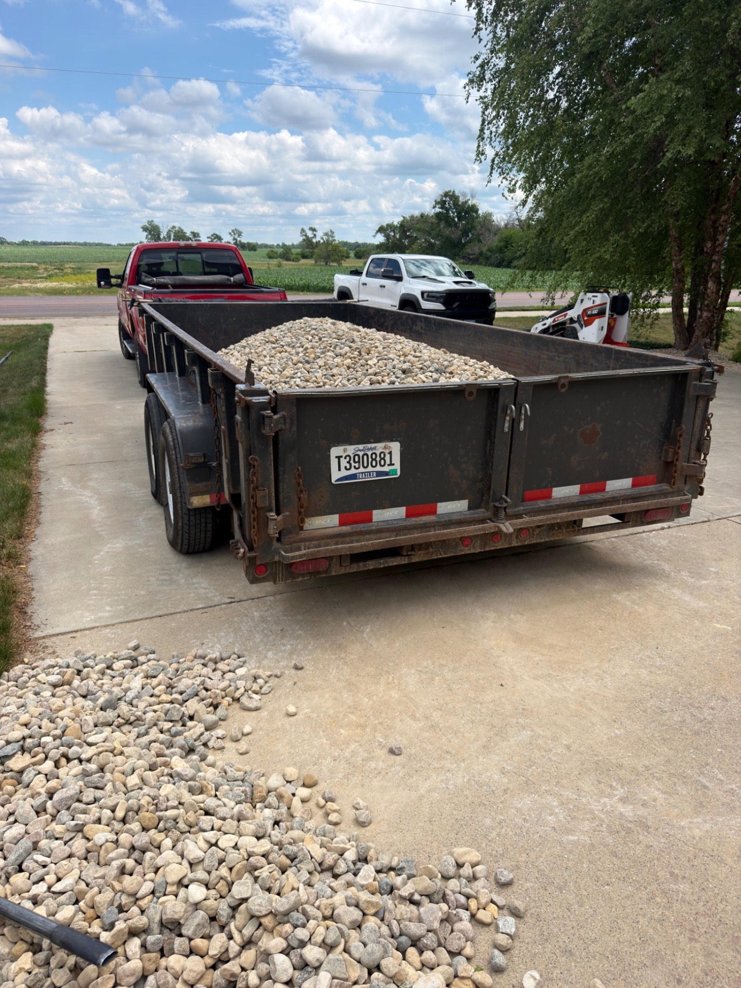 During — dump trailer loaded with river rock parked on the driveway ready to be spread into the beds