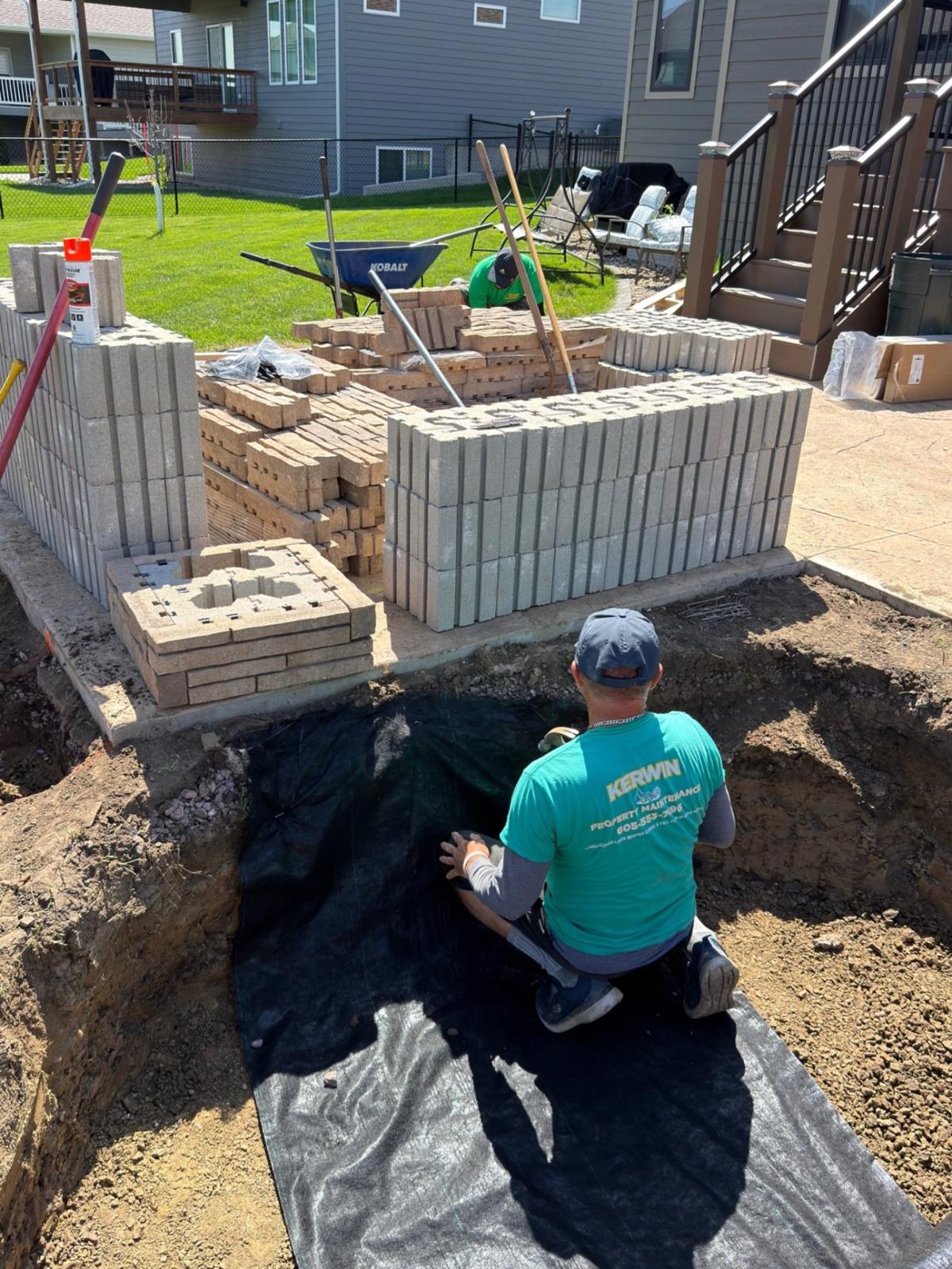 During — stacking the retaining wall blocks and setting the base for the custom curved seat wall build