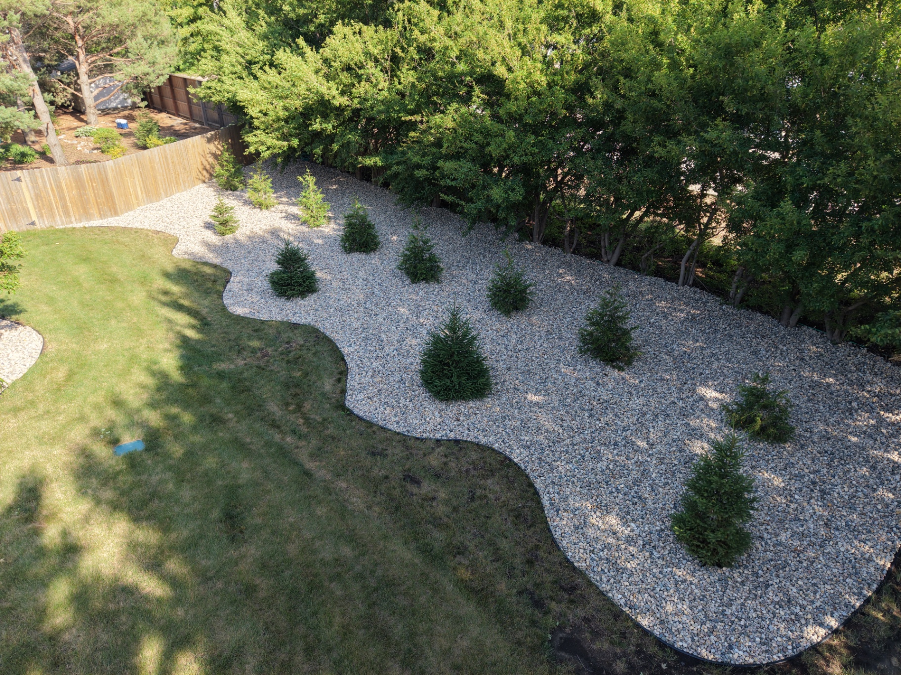 Freshly installed decorative river rock landscape bed at a Sioux Falls, SD home