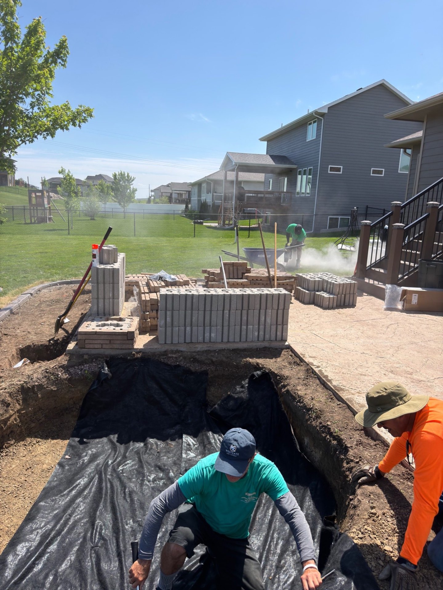 During — cutting pavers and laying the foundation courses of the seat wall next to the stamped patio