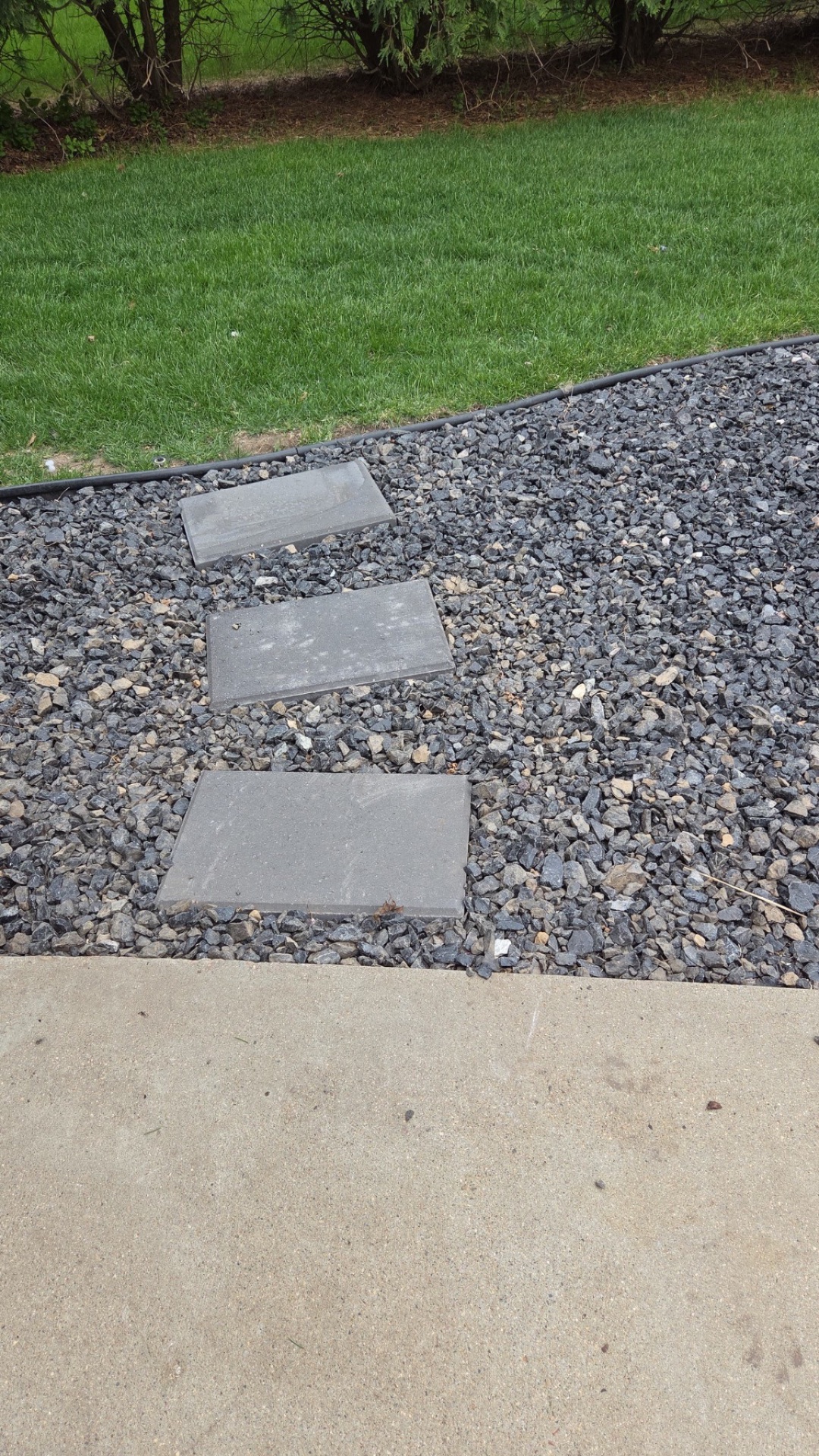 Stepping stones set into black lava rock landscaping bed